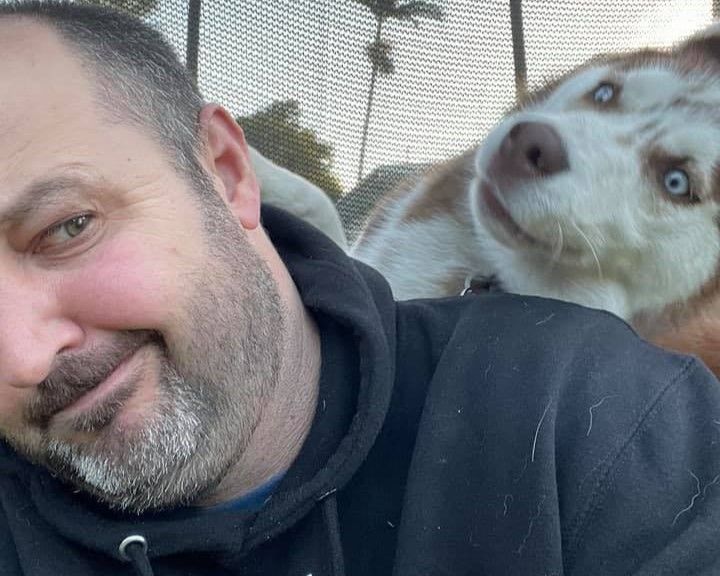 Dave and husky dog side-eyeing each other